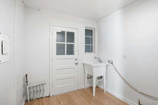 a view of an entryway with wooden floor and cabinet