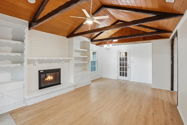 a view of a livingroom with wooden floor and a fireplace