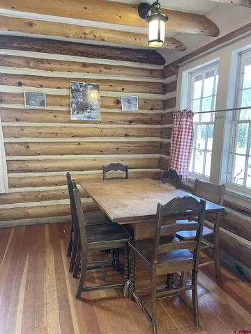 a view of a dining room with furniture a chandelier and wooden floor