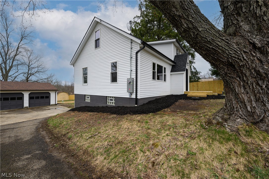 View of property exterior featuring a garage and an outdoor structure