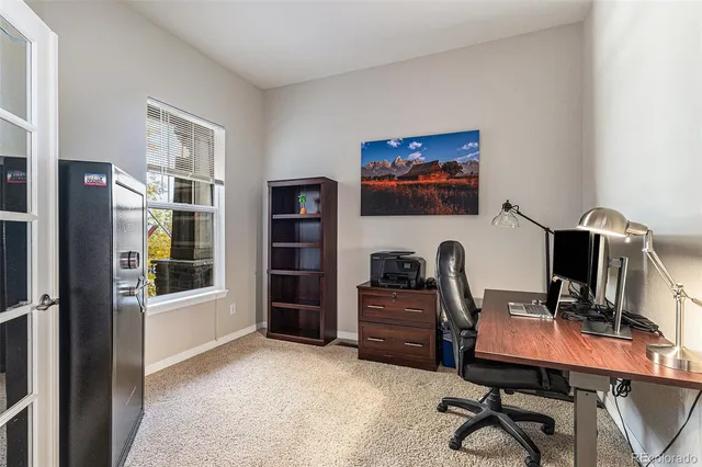 a view of a workspace with furniture and a window