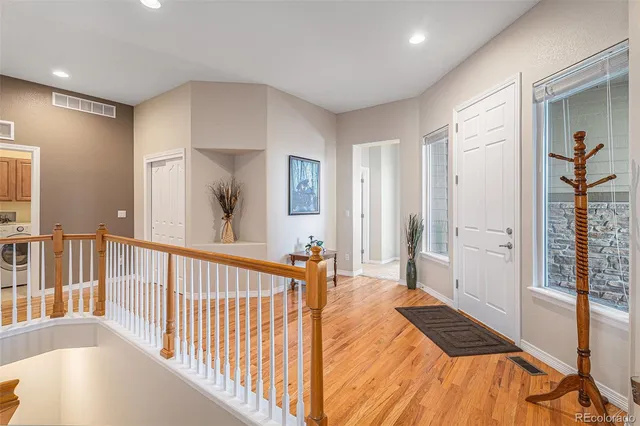 a view of a bedroom with wooden floor and windows