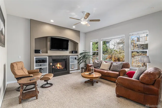 a living room with furniture a fireplace and a flat screen tv