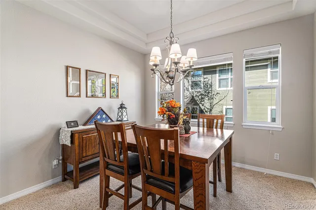 a view of a dining room with furniture a chandelier and window