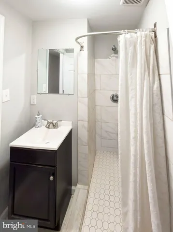 a bathroom with a sink vanity and a mirror