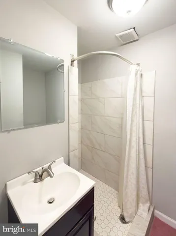 a bathroom with a sink a shower and a mirror
