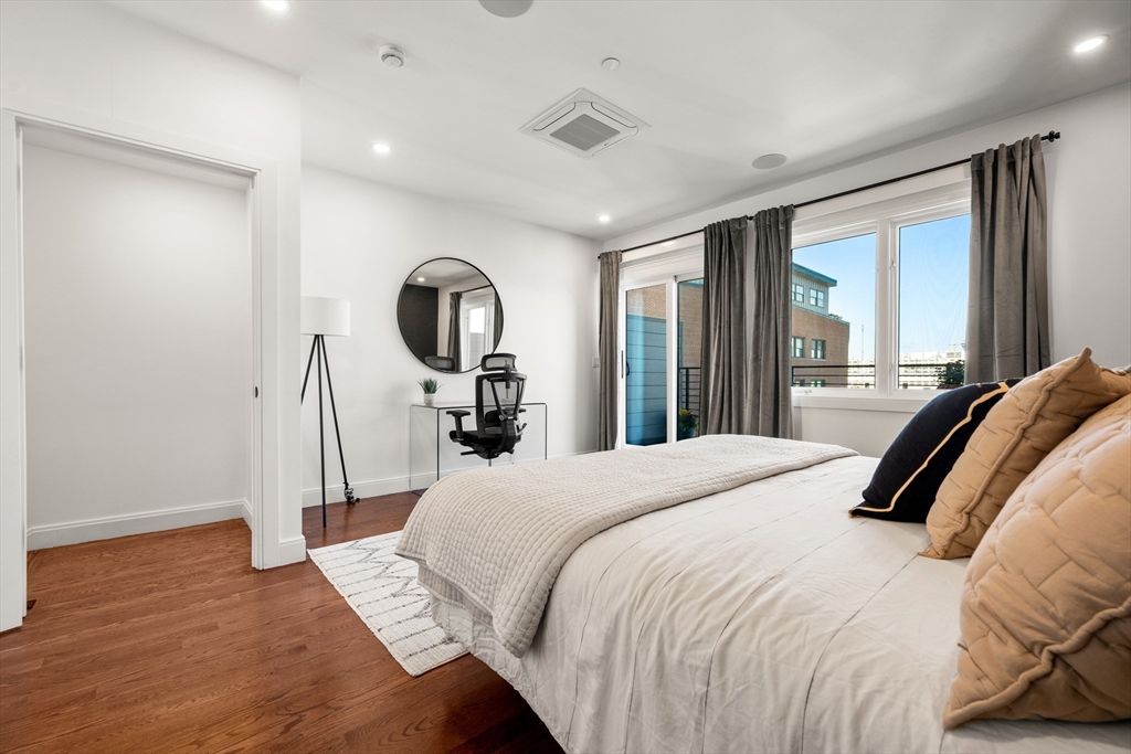 7 A Kemble Place Boston, MA 02127 - Photo 11 of 26 a bedroom with a bed a mirror and a large window