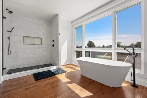 a living room with furniture a large window and wooden floor