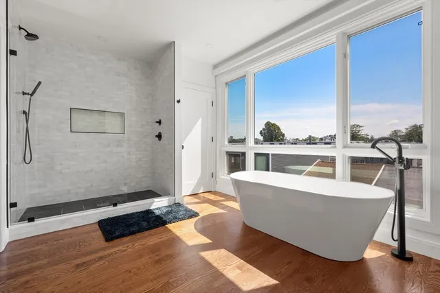 a living room with furniture a large window and wooden floor