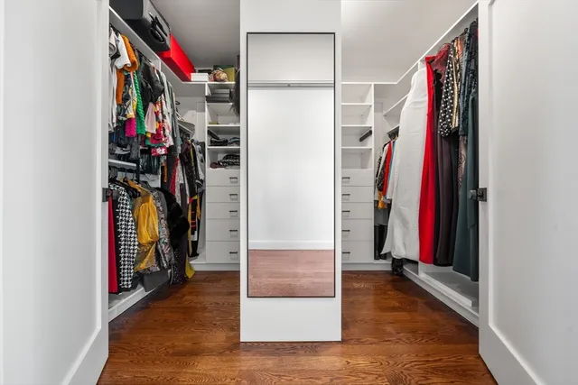 a view of walk in closet with clothes and shoes