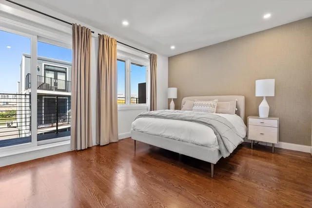 a bedroom with a large bed and wooden floor