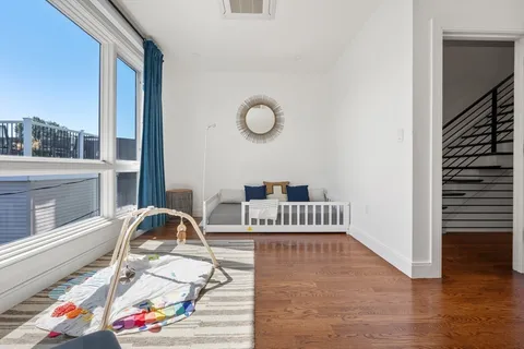 a view of a workspace with furniture and a floor to ceiling window