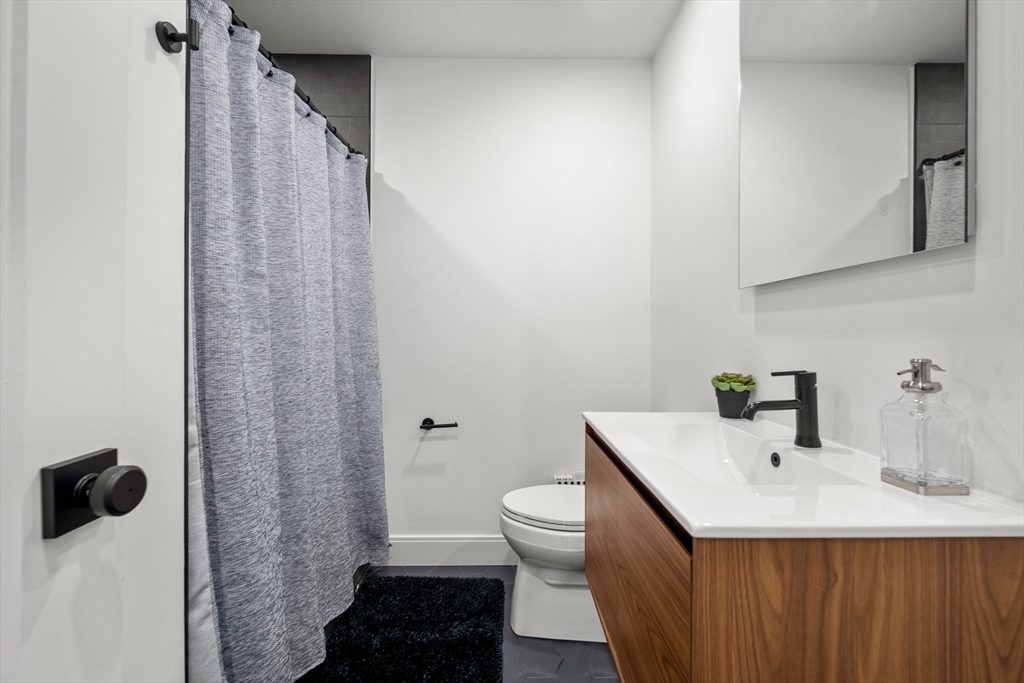 7 A Kemble Place Boston, MA 02127 - Photo 22 of 26 a bathroom with a sink a toilet and shower