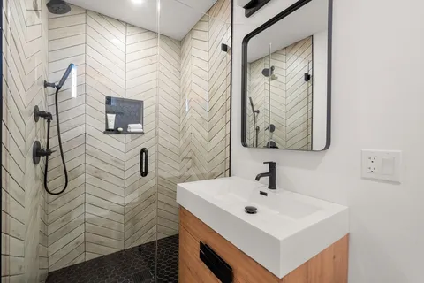 a bathroom with a sink a mirror and shower