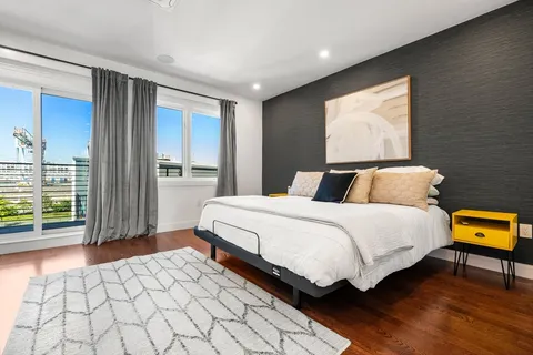a bedroom with a bed and wooden floor