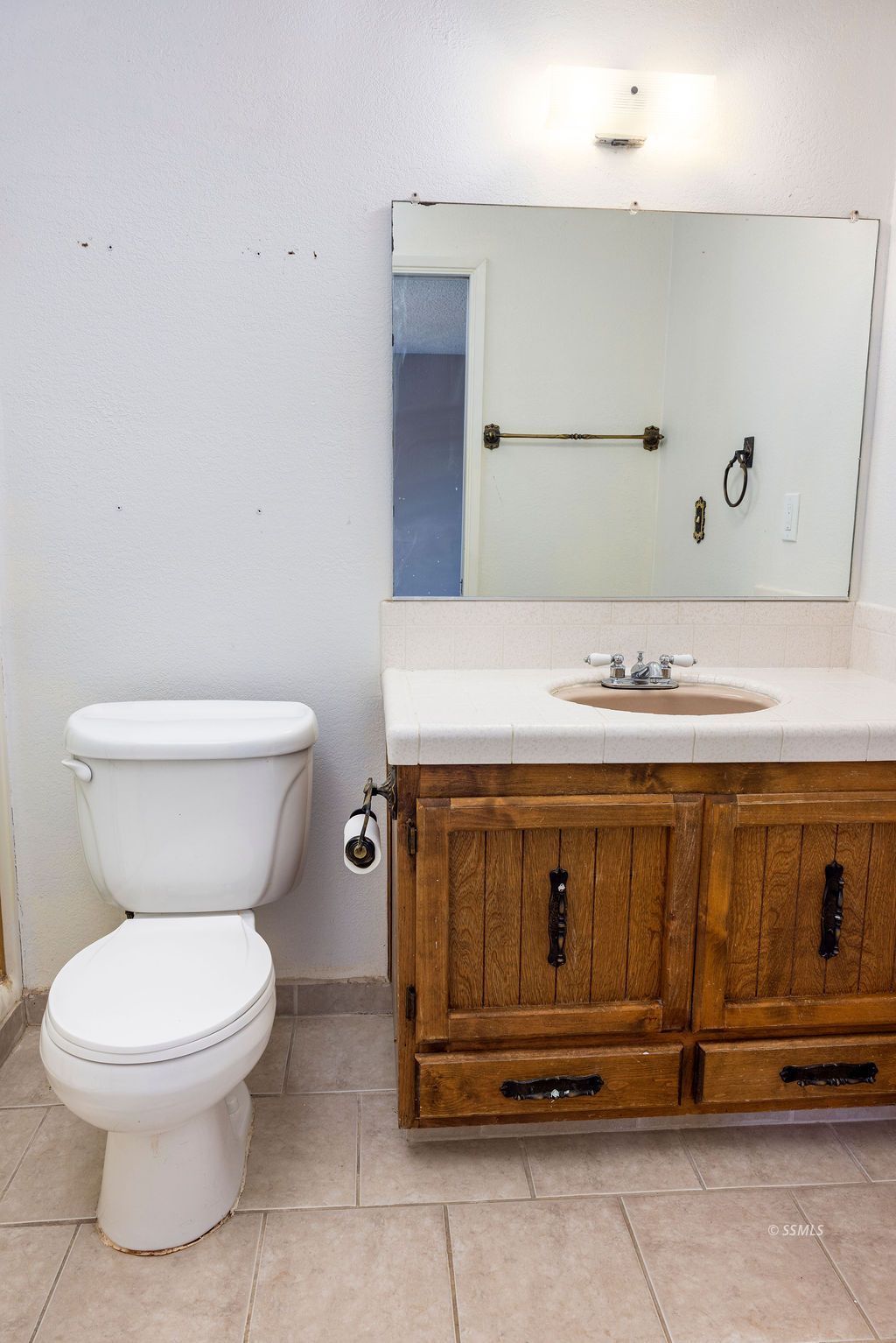 1144 West Benson Avenue Ridgecrest, CA 93555 - Photo 24 of 32 a bathroom with a toilet a sink and mirror