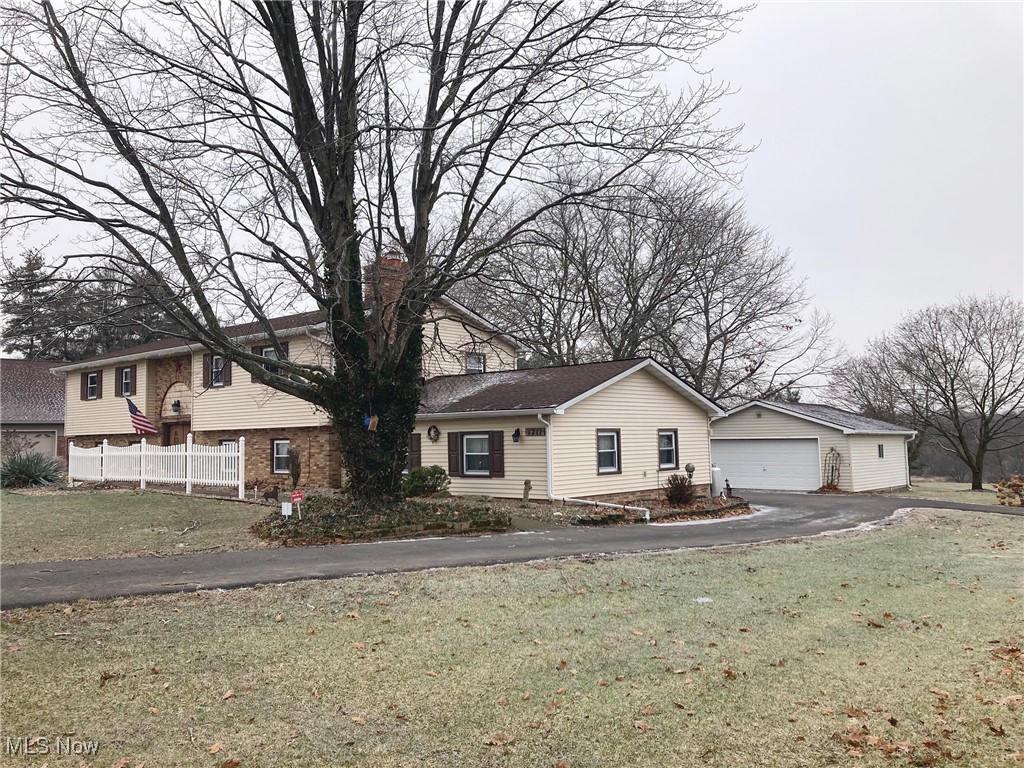1211 Slater Road Salem, OH 44460 - Photo 2 of 7 View of front of home featuring a front lawn, a chimney, a detached garage, and fence