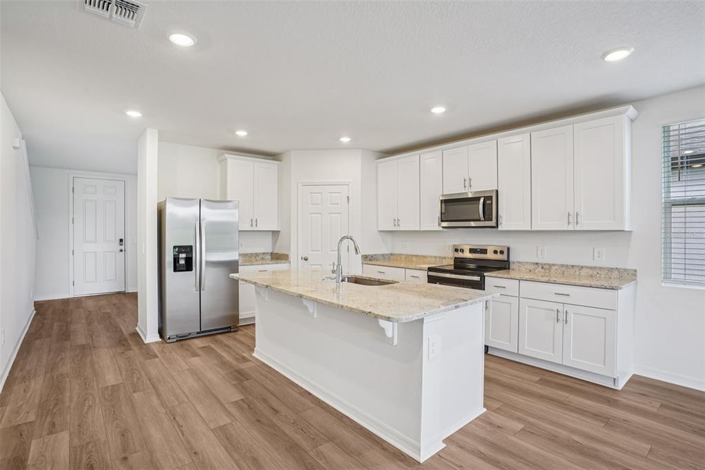 4519 Windy Oak Way St. Cloud, FL 34772 - Photo 12 of 40 a kitchen with stainless steel appliances granite countertop a white cabinets a sink a stove a refrigerator and white cabinets