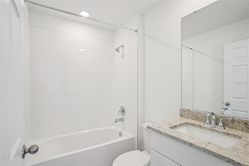 4519 Windy Oak Way St. Cloud, FL 34772 - Photo 27 of 40 a bathroom with a granite countertop bathtub shower sink vanity and toilet