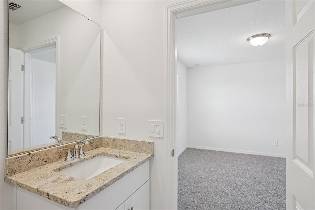 4519 Windy Oak Way St. Cloud, FL 34772 - Photo 28 of 40 a bathroom with a granite countertop sink and a mirror