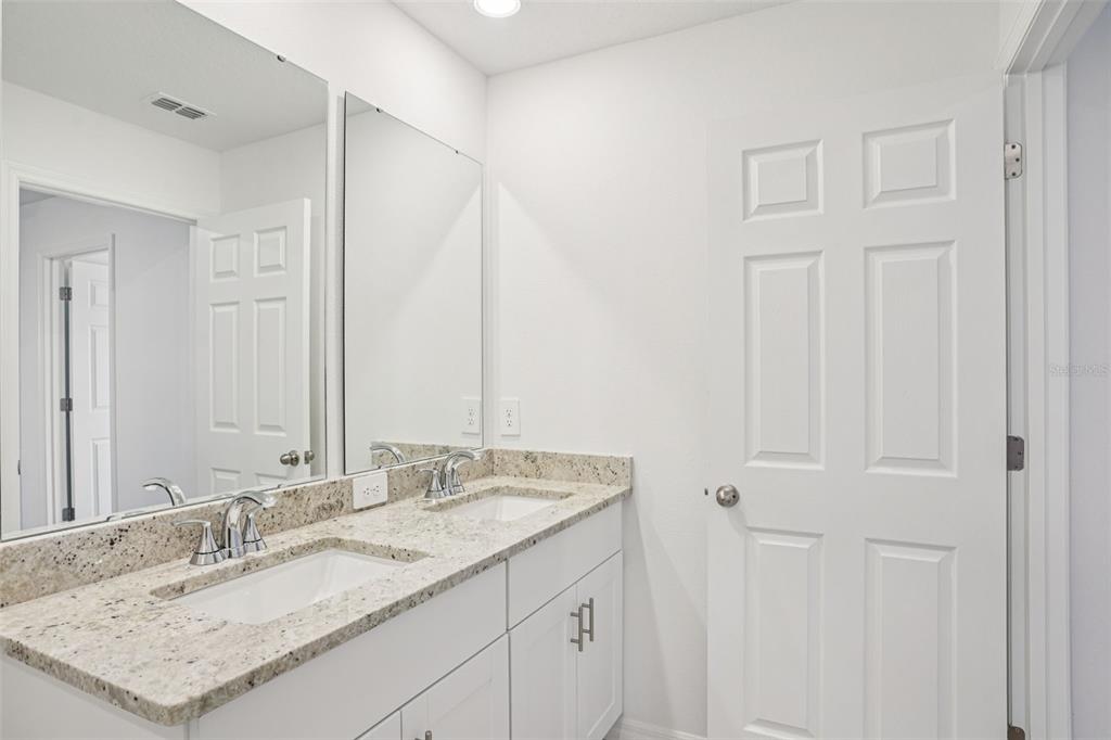 4519 Windy Oak Way St. Cloud, FL 34772 - Photo 32 of 40 a bathroom with a granite countertop sink and a mirror