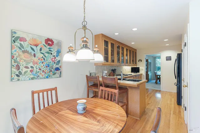 a kitchen with stainless steel appliances a dining table chairs and stove top oven