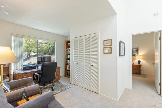 a view of a livingroom with workspace and a window