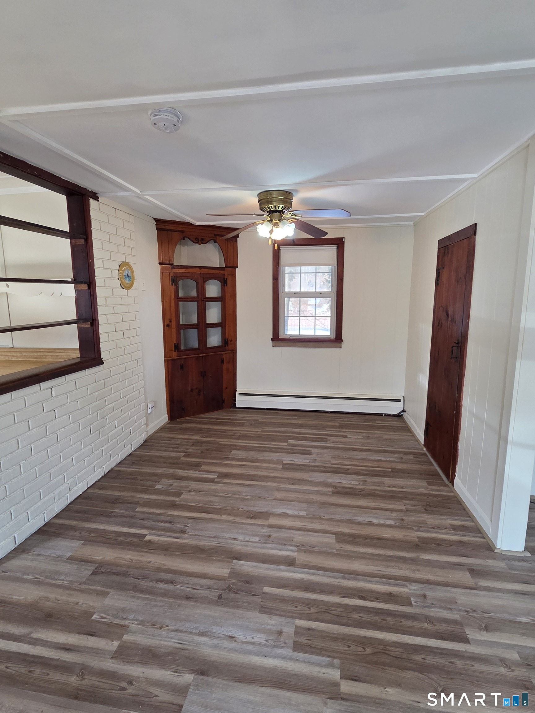 397 Buddington Road Groton, CT 06340 - Photo 6 of 13 a view of an empty room with a window and wooden floor