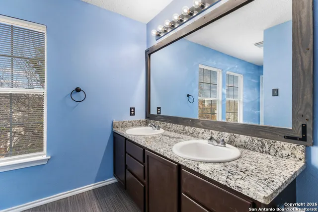 a bathroom with a granite countertop sink and a mirror
