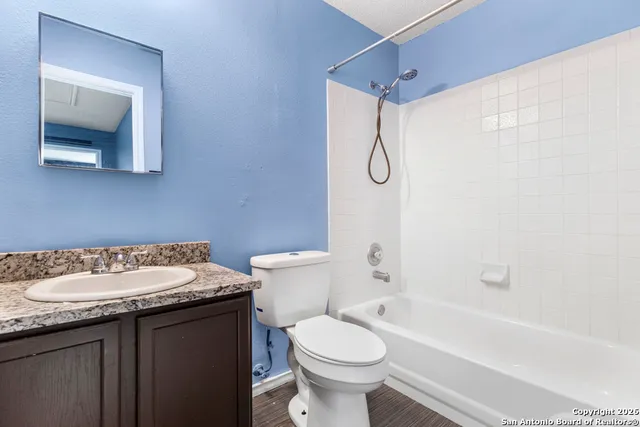 a bathroom with a granite countertop sink toilet and shower