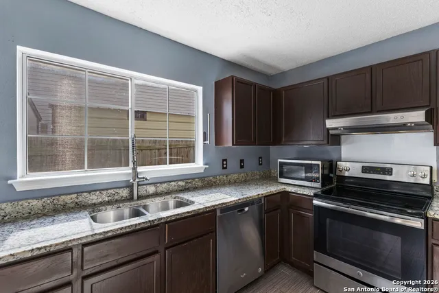a kitchen with a sink stove and cabinets