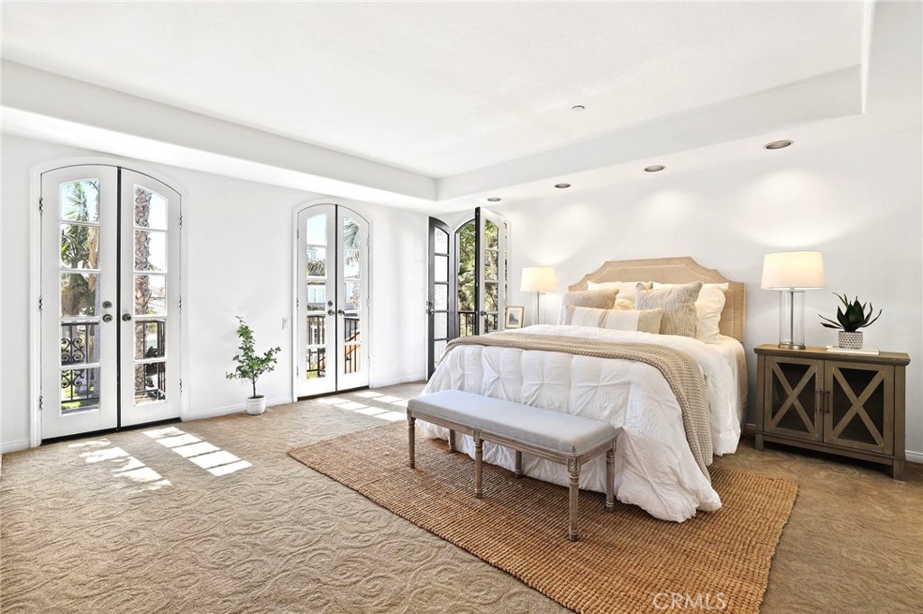 247 6th Street Seal Beach, CA 90740 - Photo 19 of 39 a spacious bedroom with a large bed and a chandelier