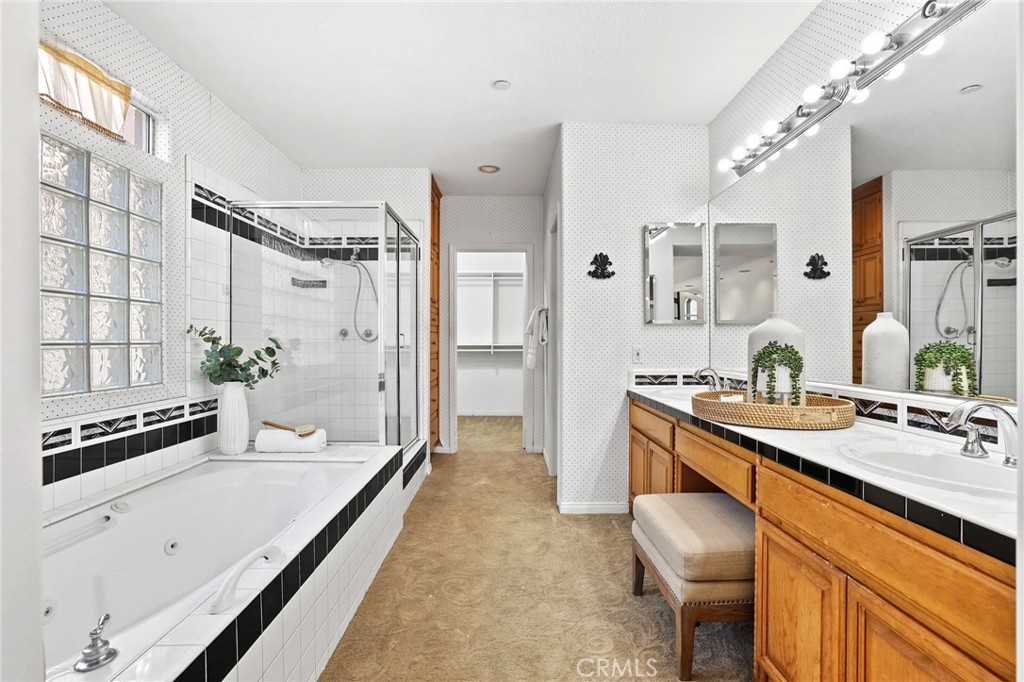 247 6th Street Seal Beach, CA 90740 - Photo 25 of 39 a spacious bathroom with a granite countertop sink a mirror a bathtub and shower