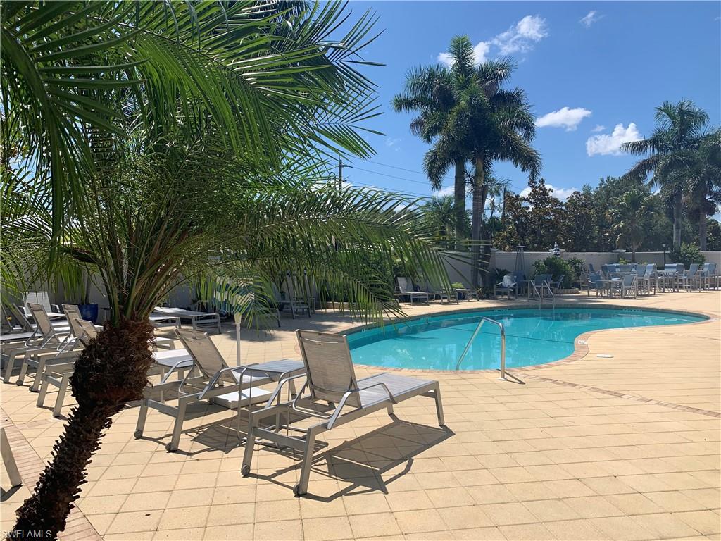10045 Heather Lane, Unit 2203 Naples, FL 34119 - Photo 13 of 23 a view of a swimming pool with lounge chairs