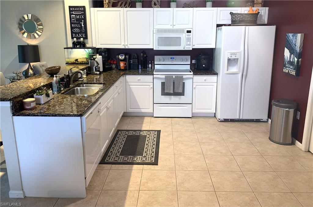 10045 Heather Lane, Unit 2203 Naples, FL 34119 - Photo 2 of 23 a kitchen with stainless steel appliances granite countertop a stove a sink and a refrigerator