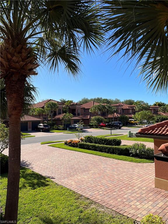 10045 Heather Lane, Unit 2203 Naples, FL 34119 - Photo 23 of 23 a view of a swimming pool with a yard and palm trees
