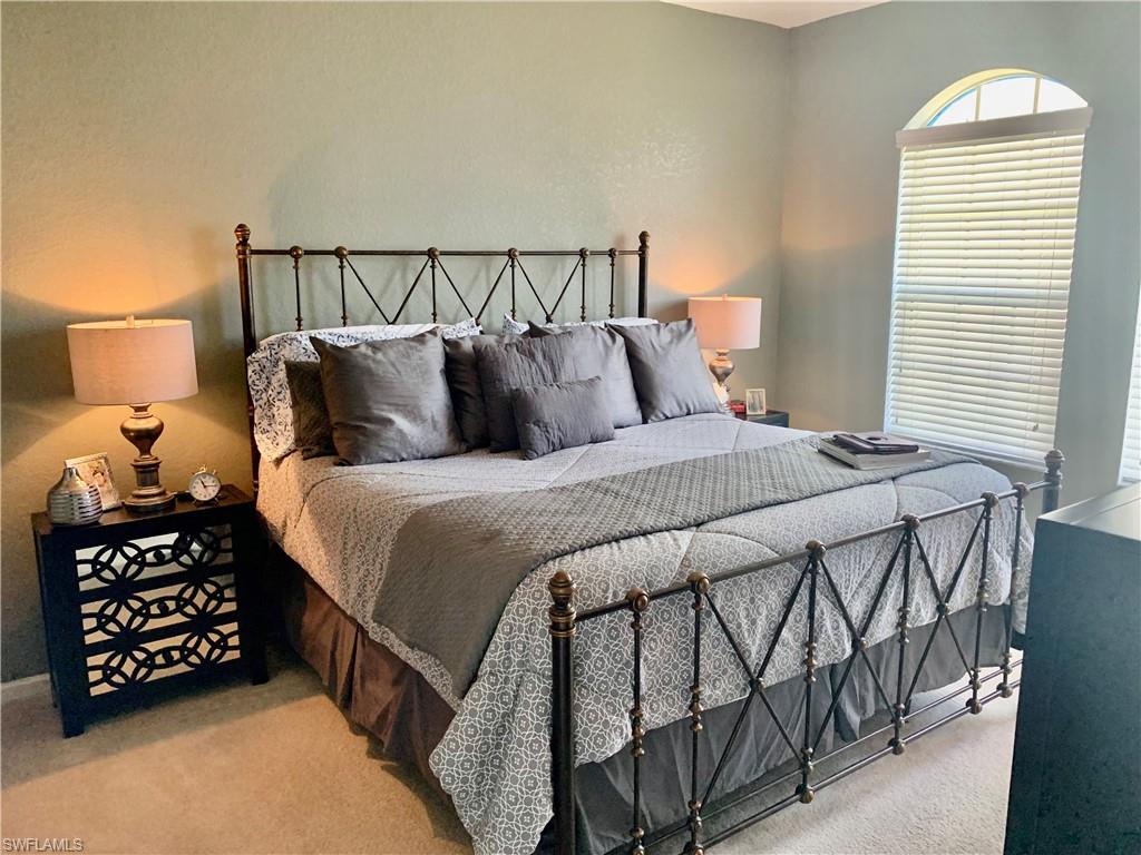 10045 Heather Lane, Unit 2203 Naples, FL 34119 - Photo 5 of 23 a bedroom with a bed and a lamp on dresser