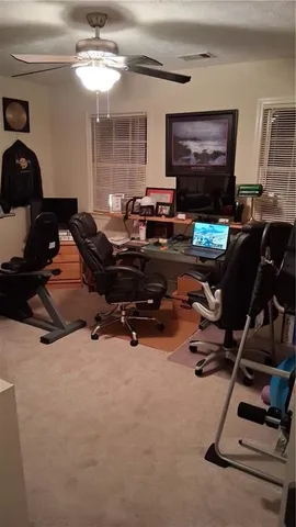 a living room with furniture gym equipment and a flat screen tv