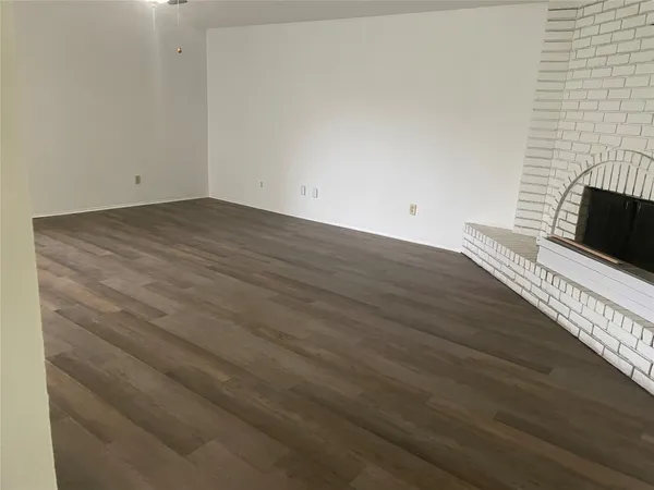 a view of a room that has wooden floor and a fireplace