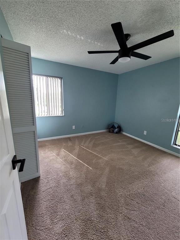 1801 East Lake Road South, Unit 15E Palm Harbor, FL 34685 - Photo 14 of 24 an empty room with windows and fan