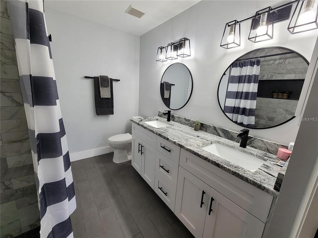 1801 East Lake Road South, Unit 15E Palm Harbor, FL 34685 - Photo 10 of 24 a bathroom with 2 sink and a mirror