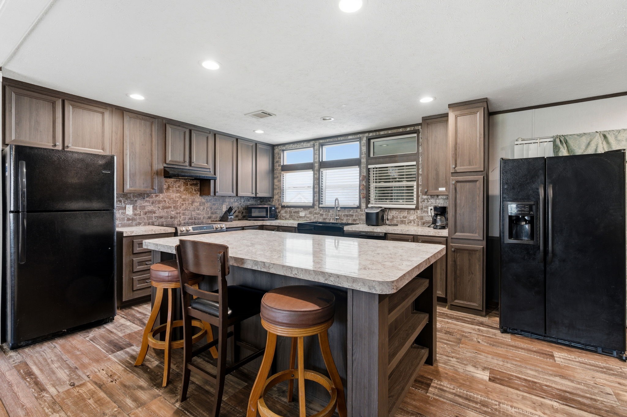 3110 Green Forest Road Conroe, TX 77303 - Photo 6 of 50 a kitchen with a refrigerator a stove and a microwave oven with wooden floor