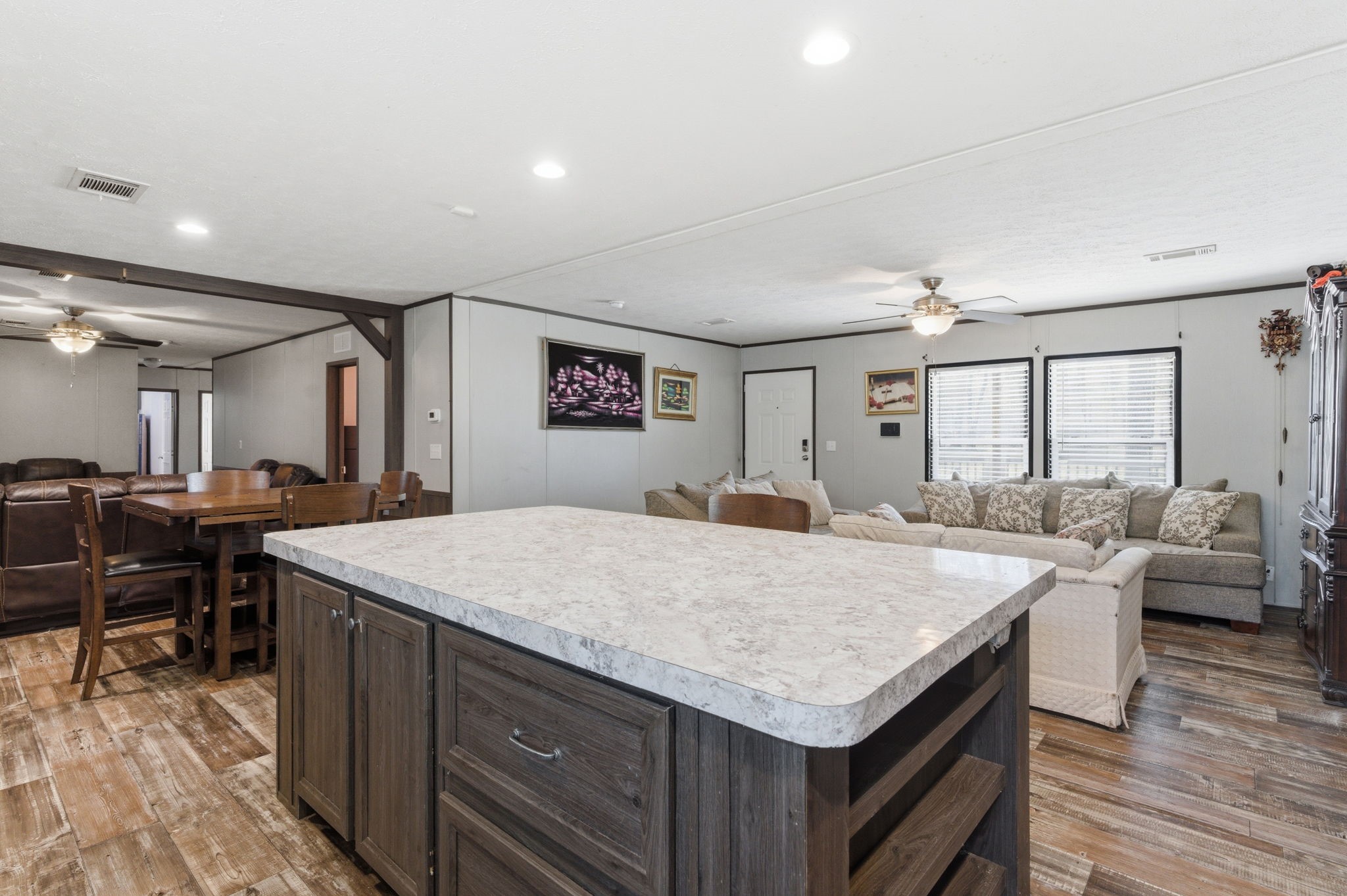 3110 Green Forest Road Conroe, TX 77303 - Photo 8 of 50 a hall with kitchen island a sink dishwasher a dining table and chairs with wooden floor