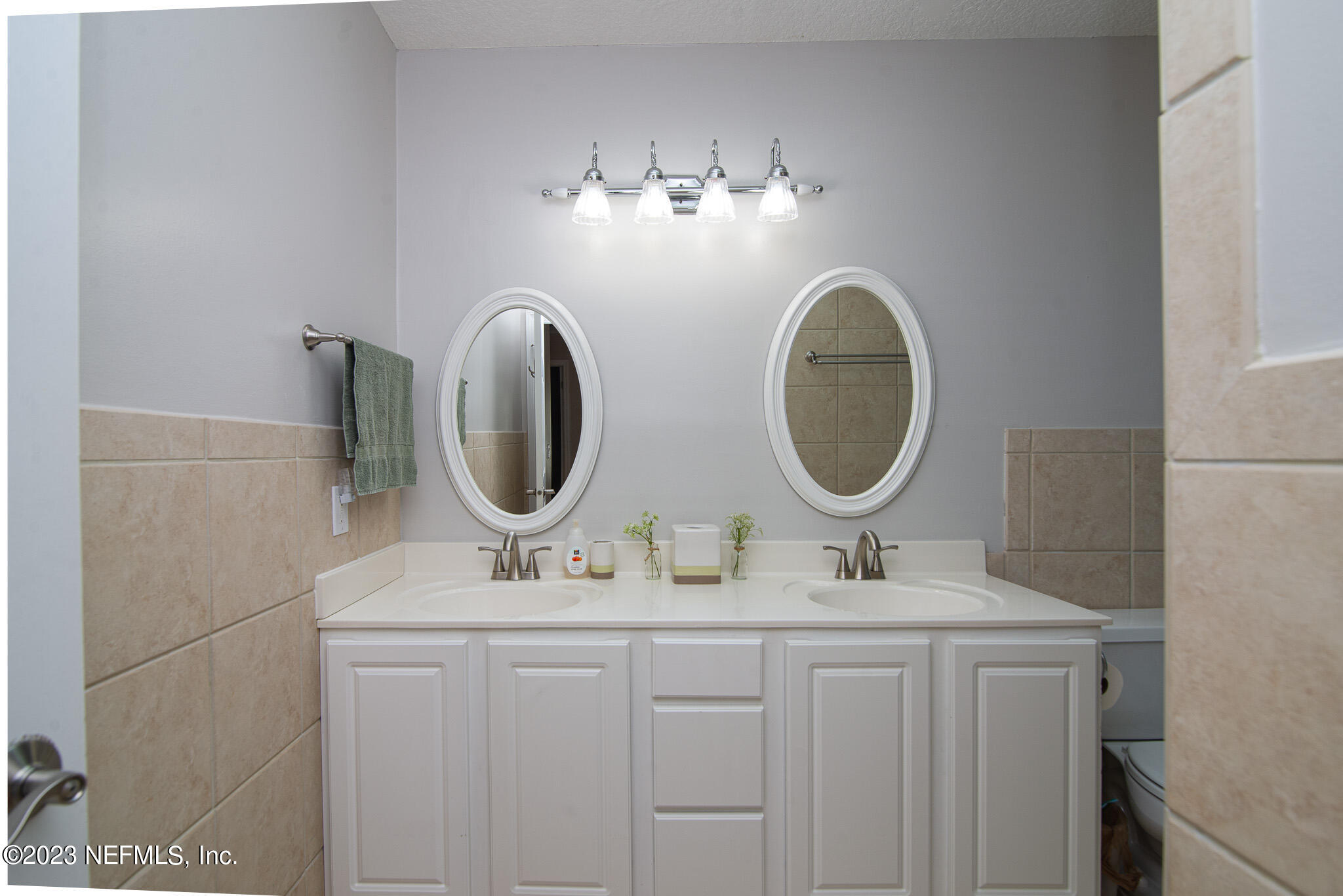 9409 Woodhaven Road Jacksonville, FL 32257 - Photo 27 of 38 a bathroom with a double vanity sink and a mirror