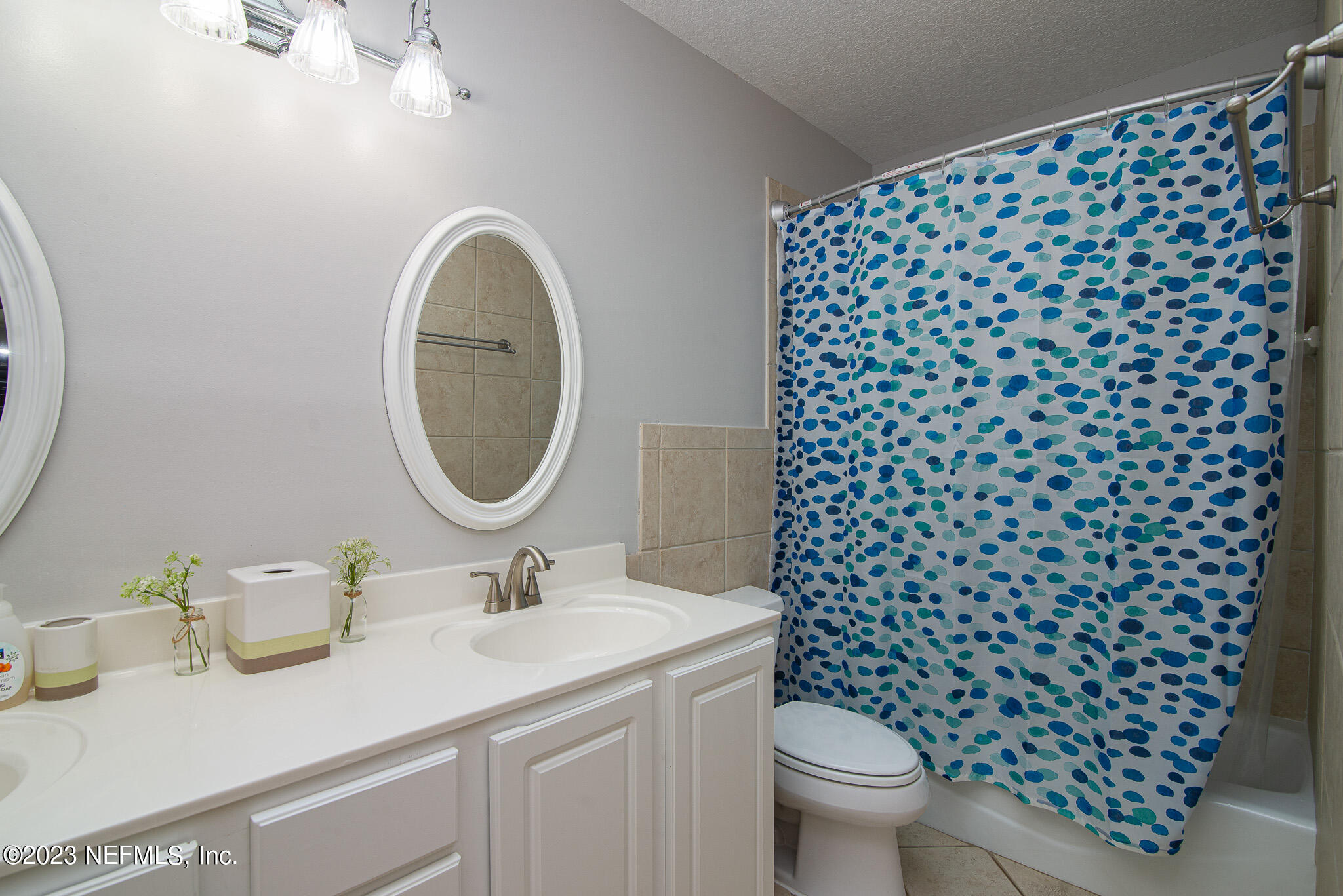 9409 Woodhaven Road Jacksonville, FL 32257 - Photo 28 of 38 a bathroom with a granite countertop toilet a sink and a mirror