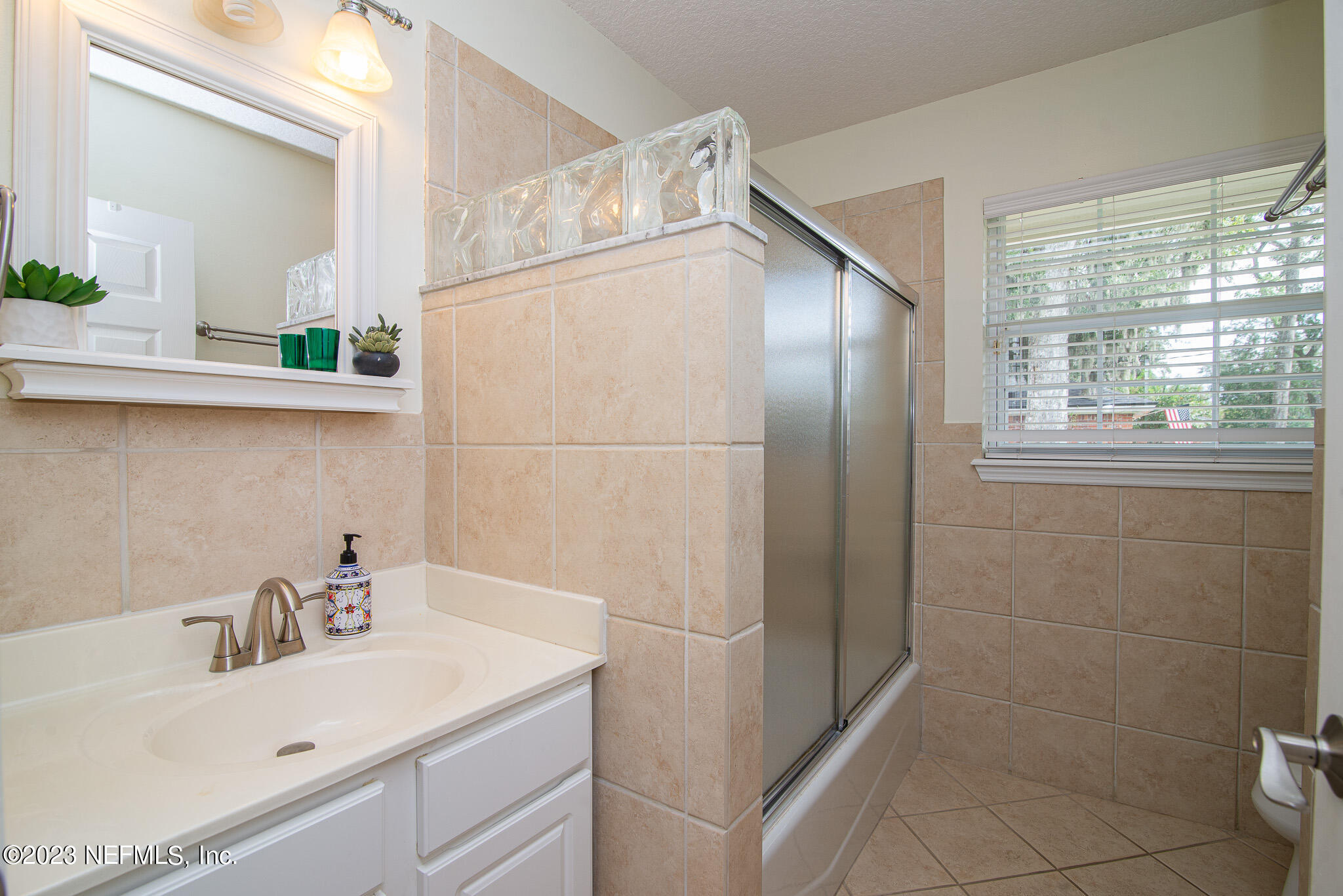 9409 Woodhaven Road Jacksonville, FL 32257 - Photo 30 of 38 a bathroom with a sink and mirror