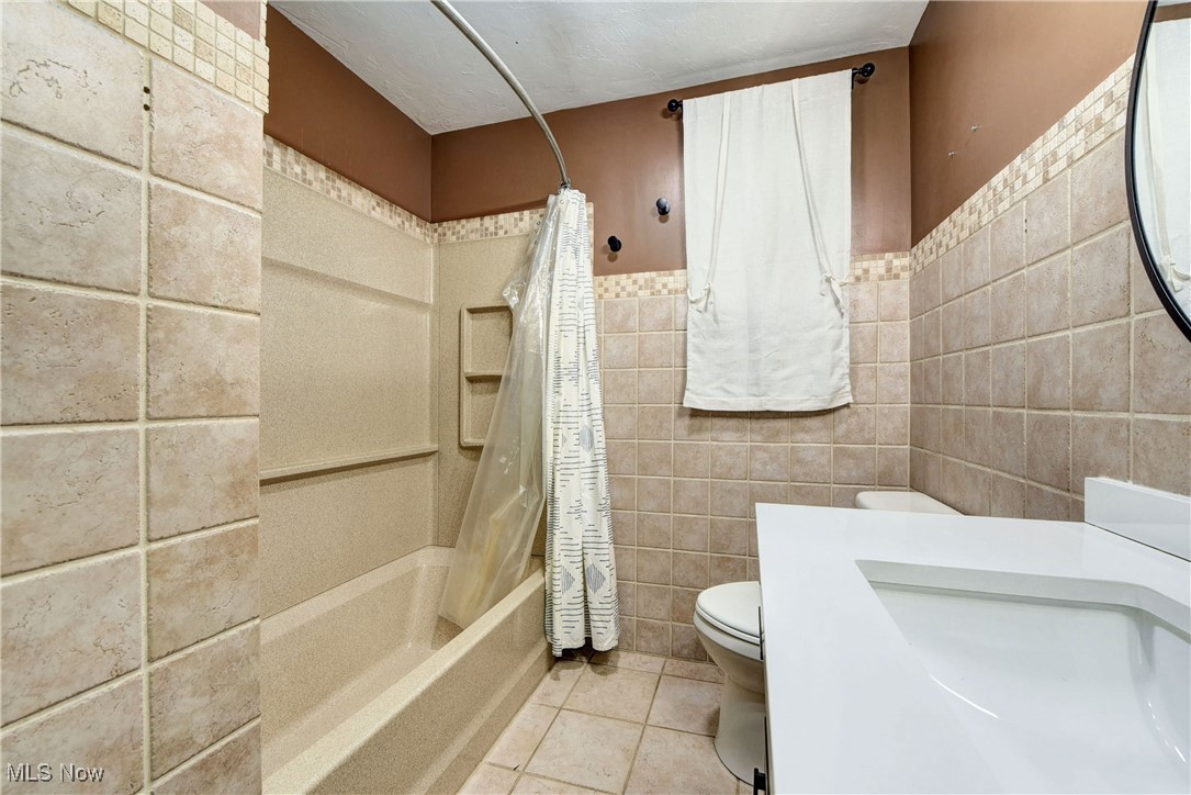 11518 Prospect Road Strongsville, OH 44149 - Photo 22 of 46 Bathroom with shower / tub combo, tile walls, toilet, tile patterned floors, and a sink