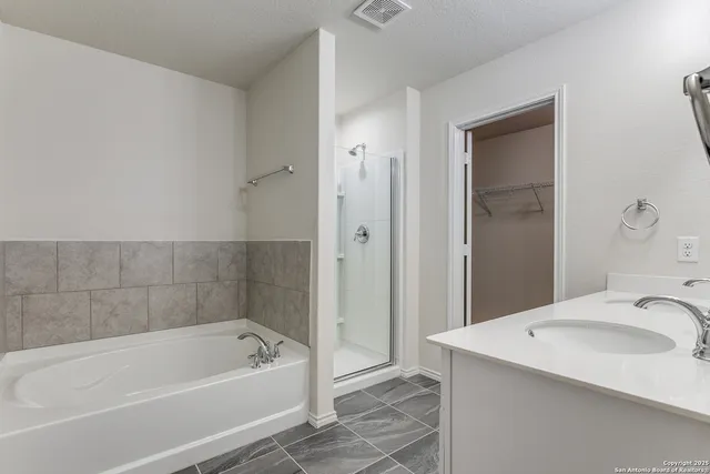 a bathroom with a tub a sink and a mirror