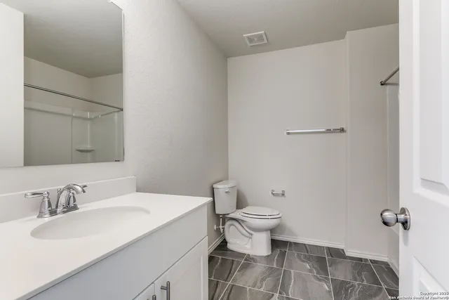 a bathroom with a sink toilet and a mirror