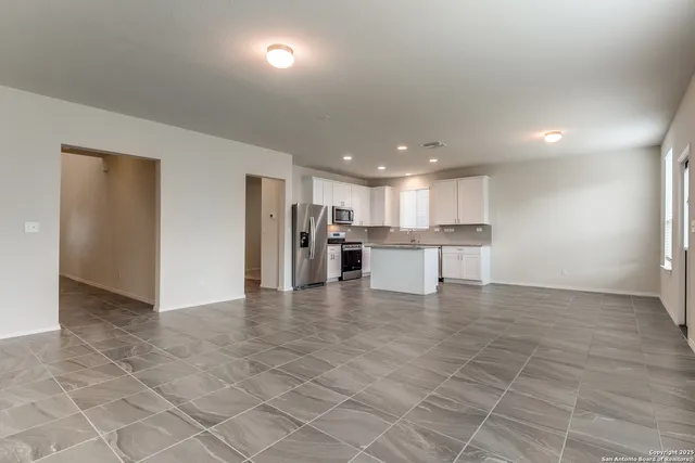 a view of kitchen with refrigerator and cabinets